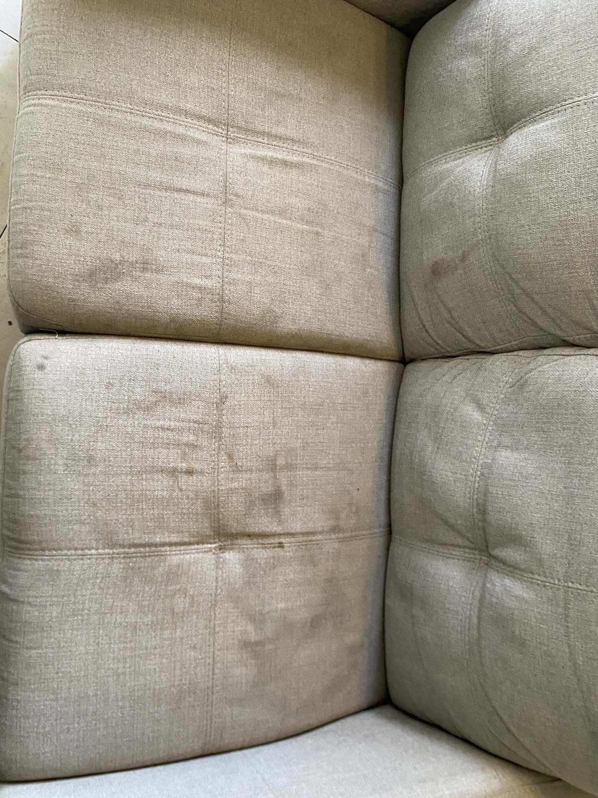 Fabric lounge cushions with dark marks before cleaning